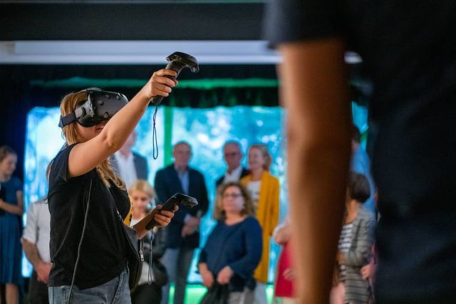 People observing woman having fun in VR